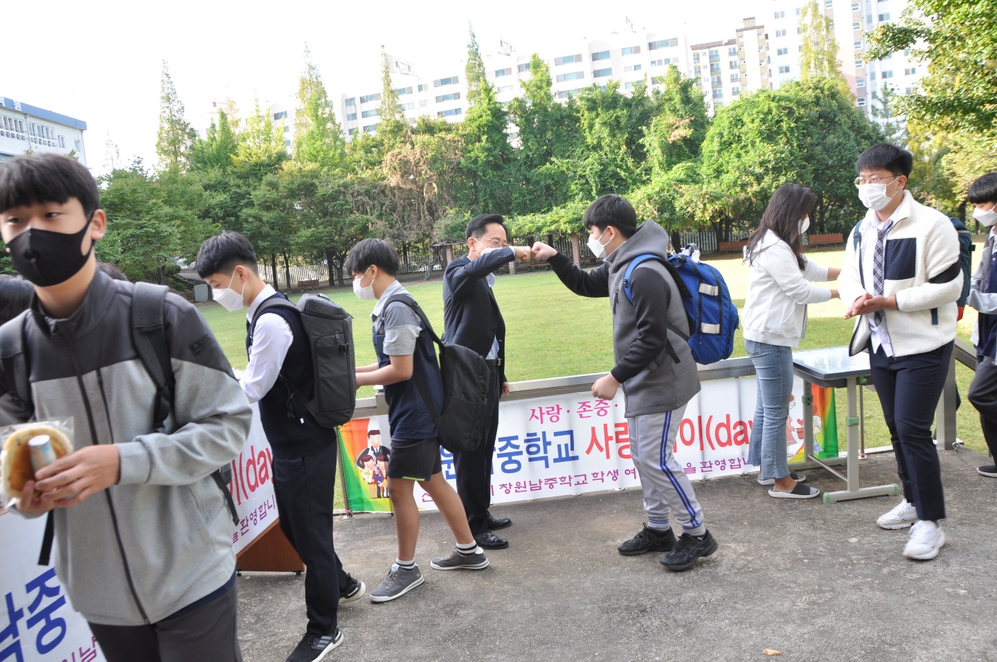[사진설명-좌측] 코로나19 중 10월 사랑데이, 교장 선생님과 손 인사하는 학생들의 모습