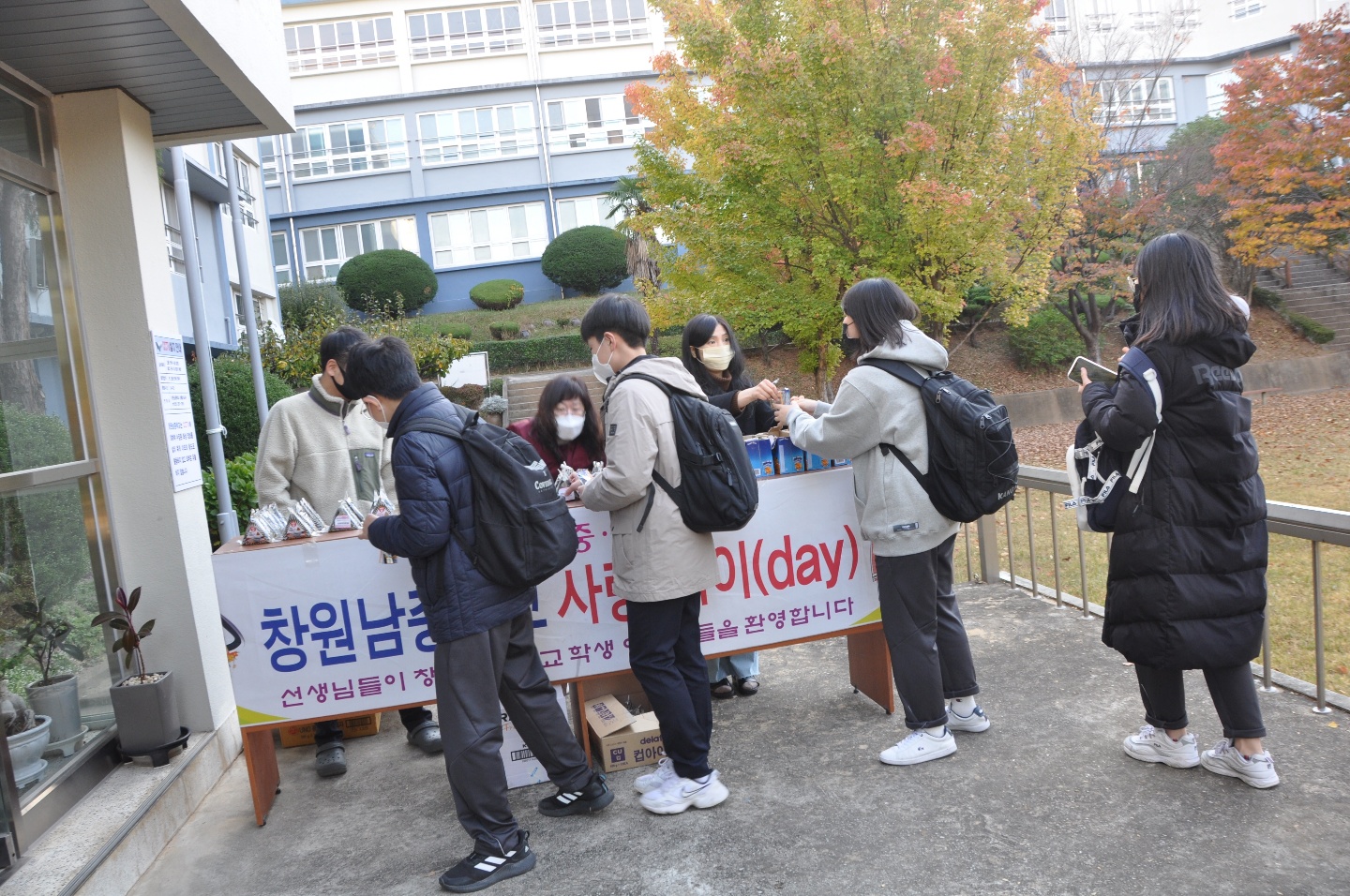 [사진설명-우측] 코로나19 중 12월 사랑데이, 등굣길 학생들에게 간식을 나눠주는 선생님 모습